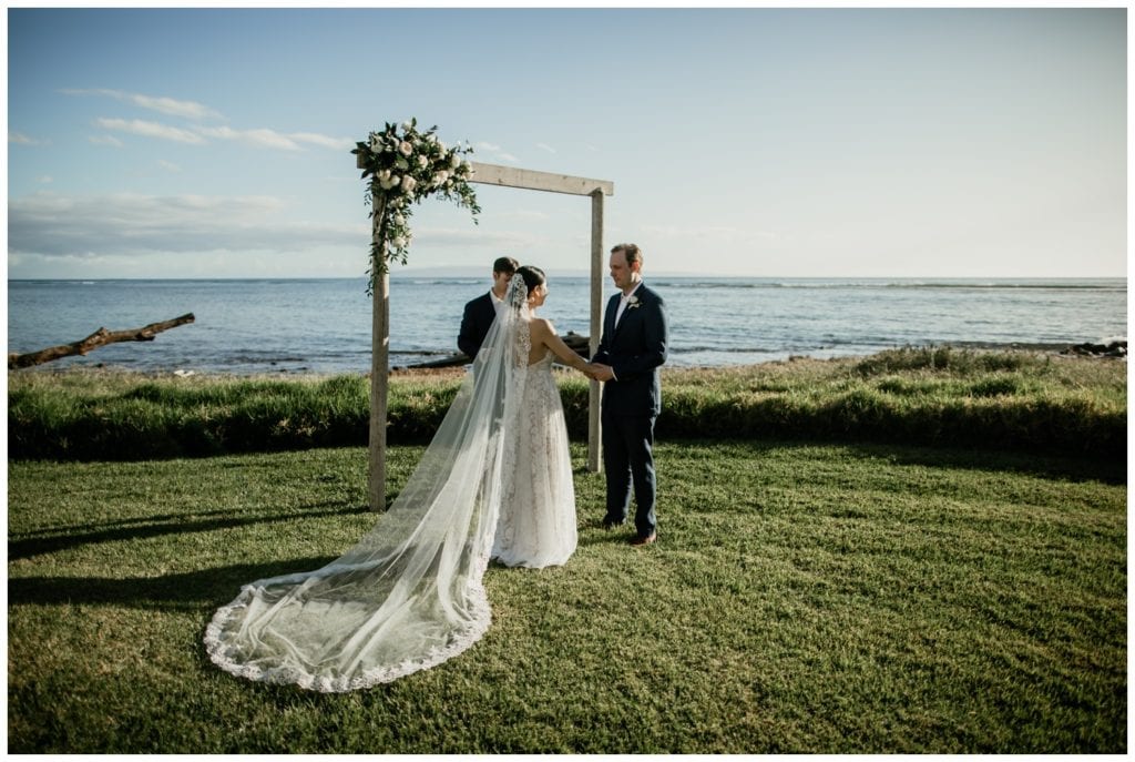 Olowalu Wedding Elopement Photographer picture of bride and groom getting married beside the ocean under ceremony arch