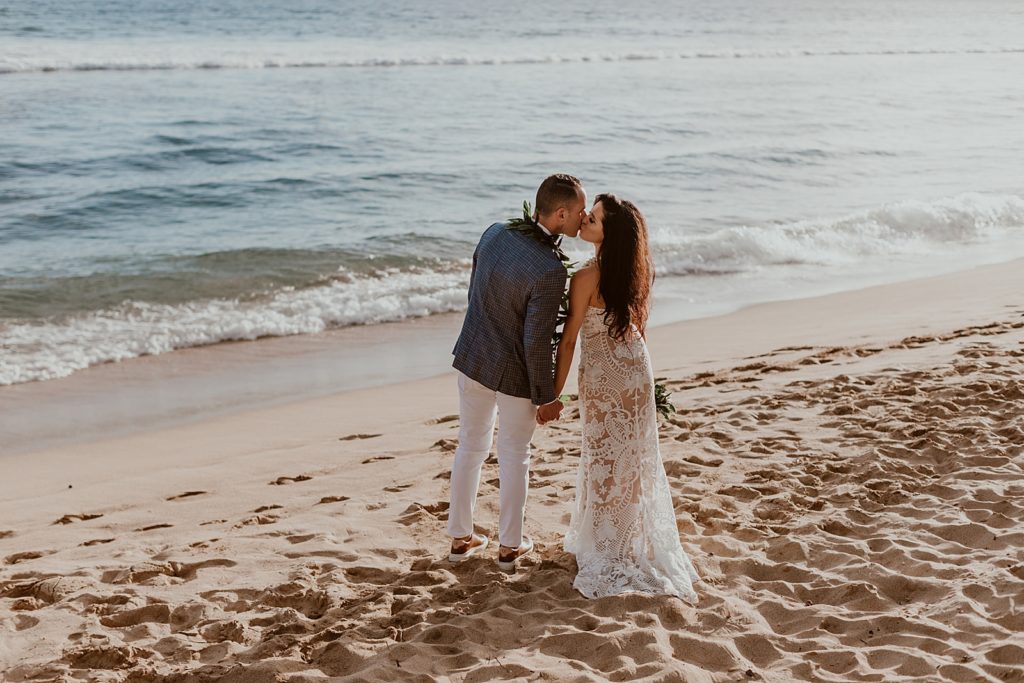Bride and Groom kissing out on beach by the ocean