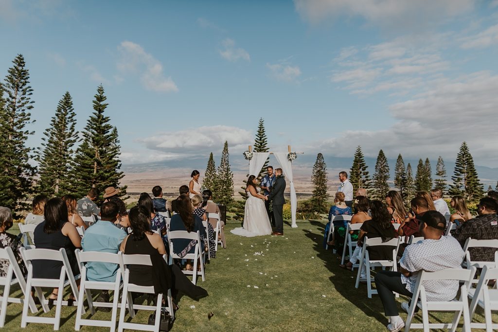 Wide shot of outdoor Ceremony of Bride and Groom holding hands
