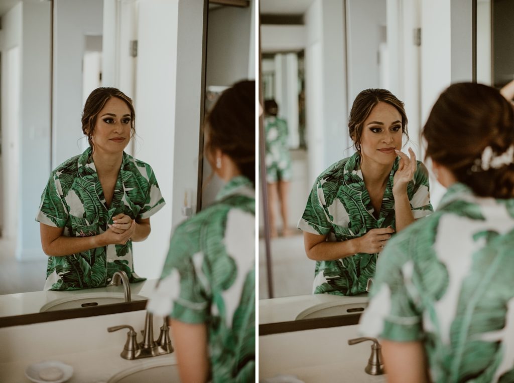 Bride looking in mirror adjusting makeup