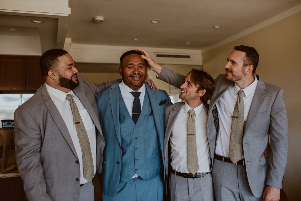 Groom with blue suit on with Groomsmen in grey suits