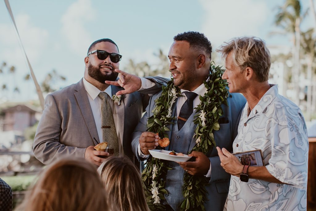 Groom eating coconut shrimp with guests