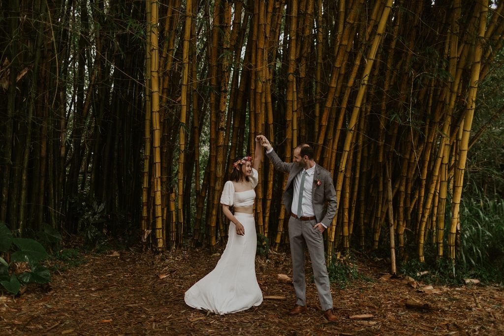 Bride twirling by Groom's hand by bamboo