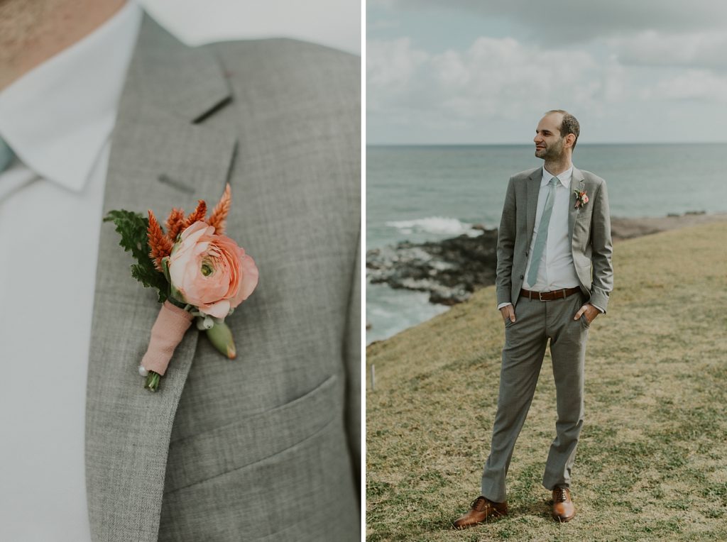 Closeup of pink flower boutonniere on grey suit 