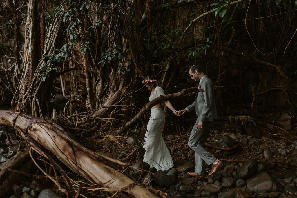 Bride holding Groom's hand and leading him through dark forest