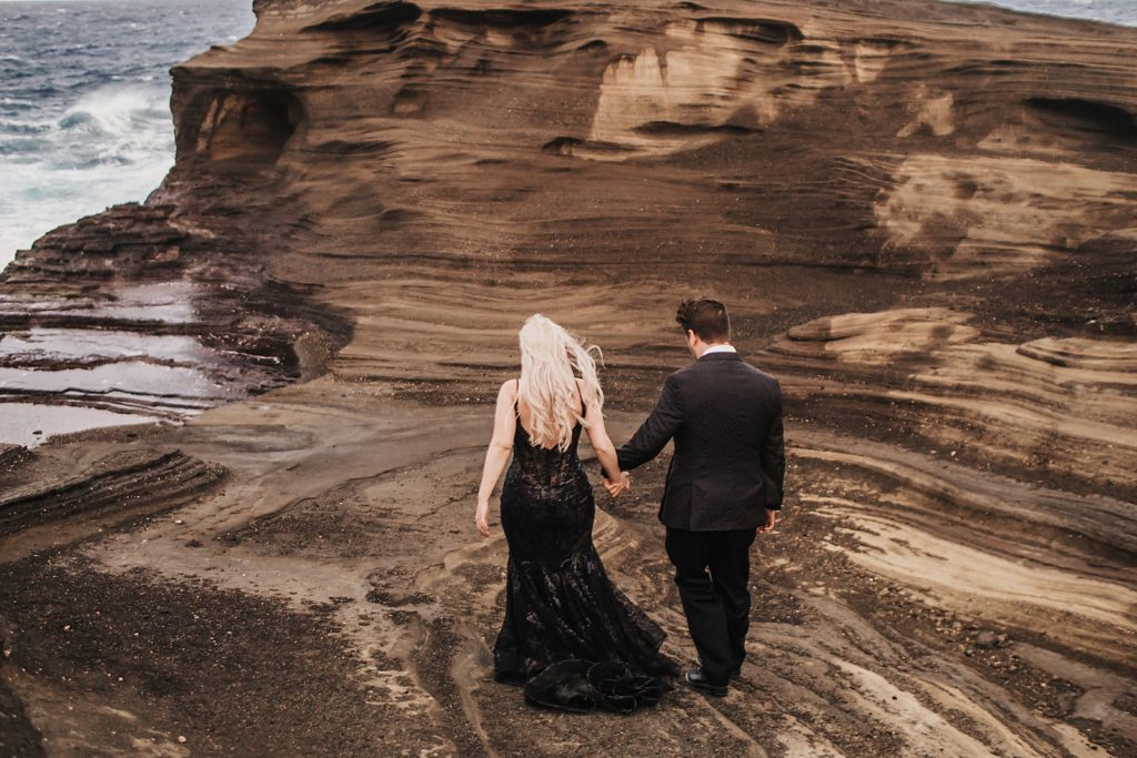 Bride and Groom holding hands and walking on sand together