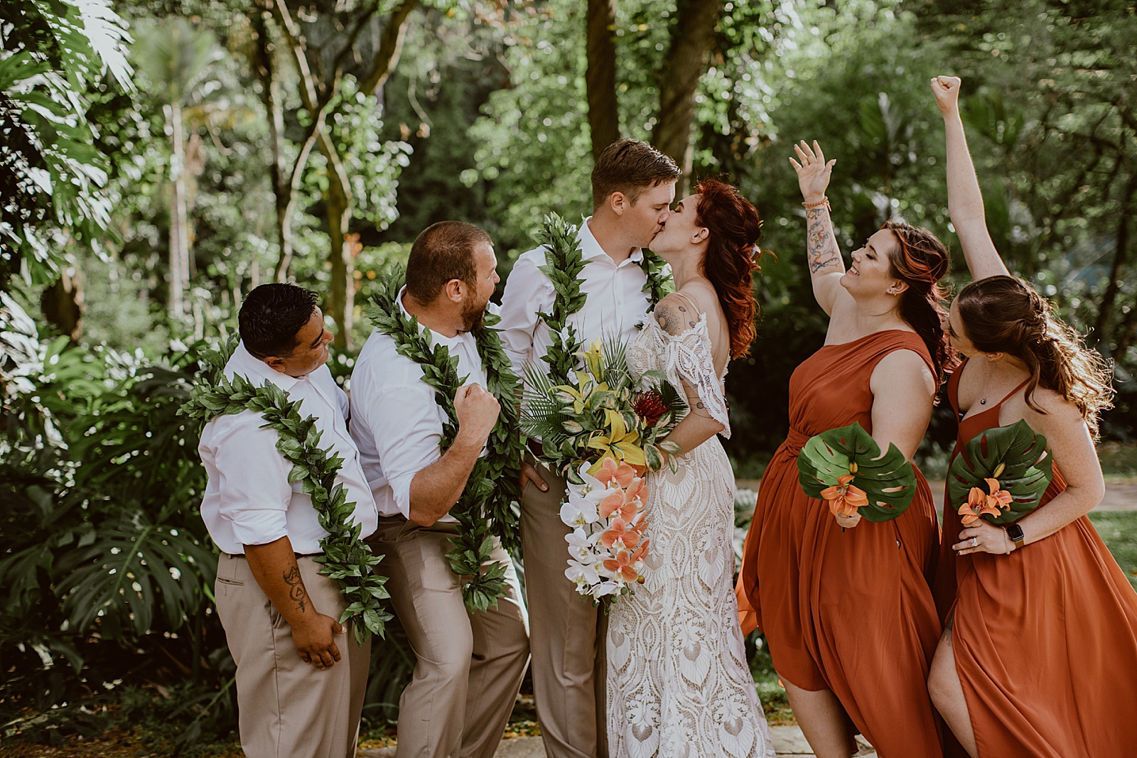 Bride and Groom kissing with wedding party celebrating