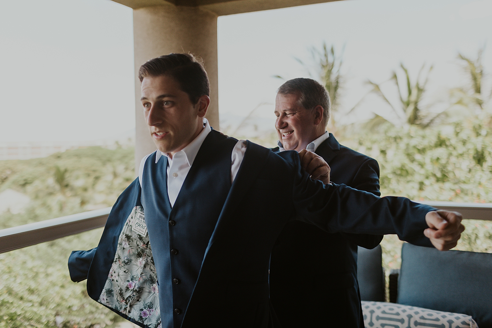 Groom getting help to put jacket on outside