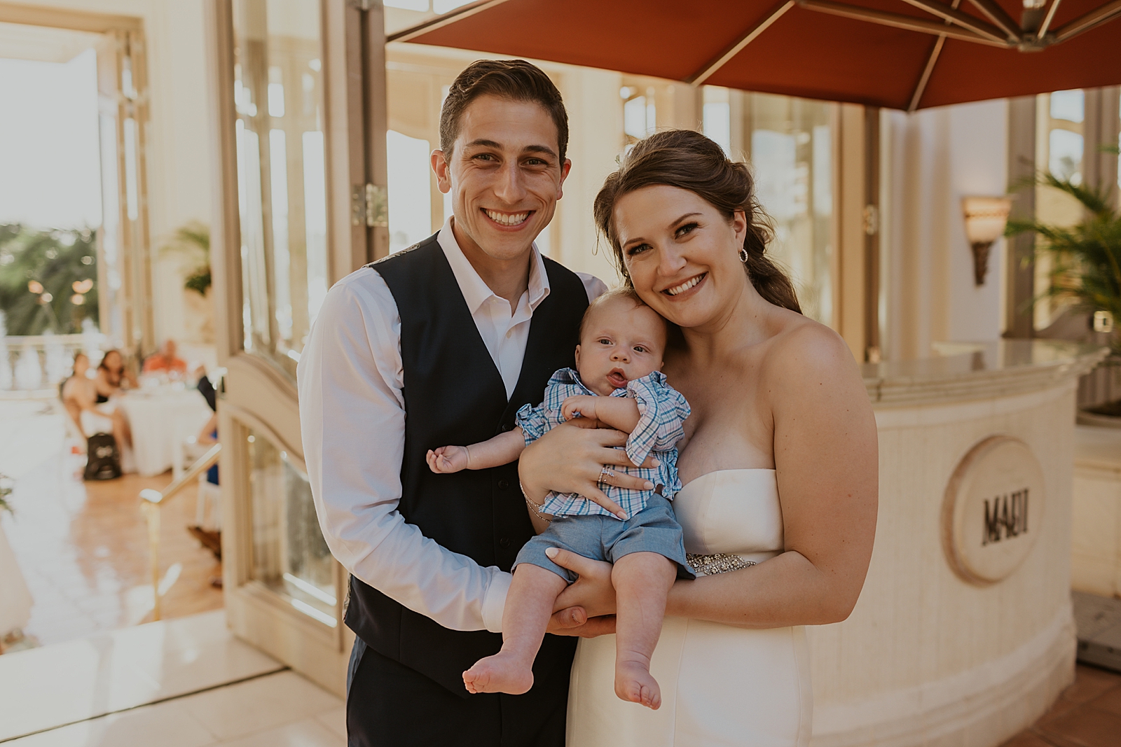 Bride and Groom holding Baby together at Reception