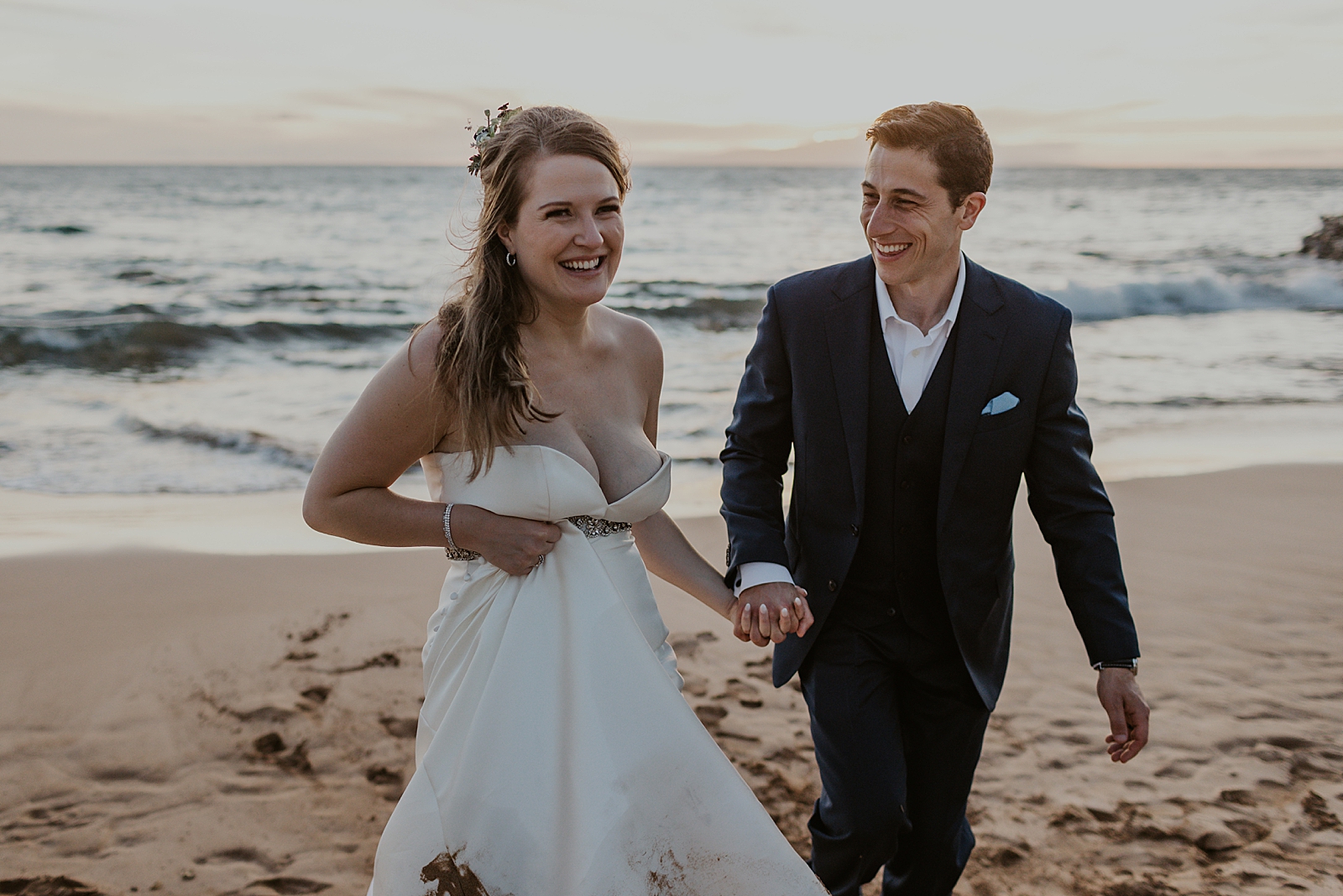 Bride and Groom holding hands and walking on the beach together