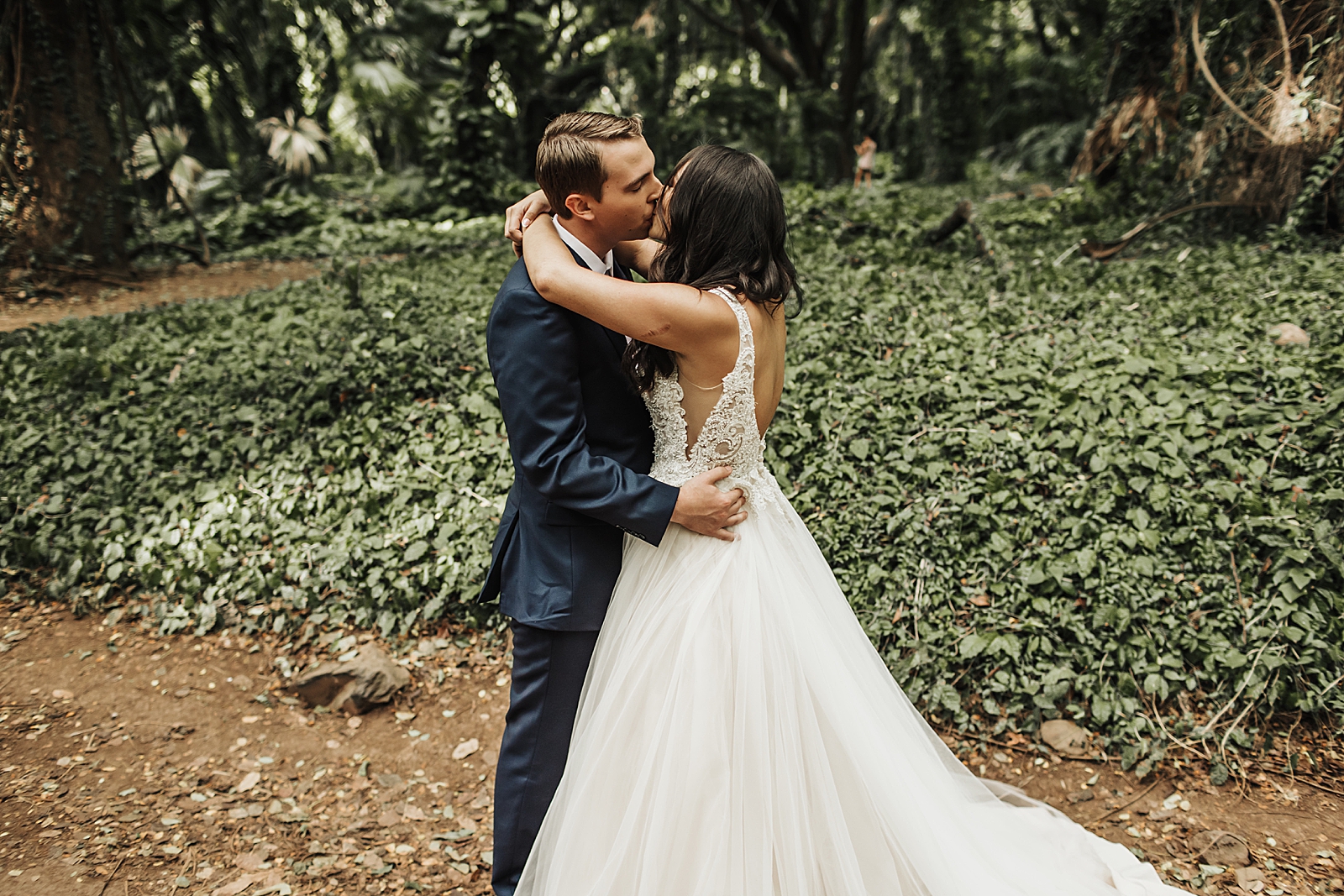 Bride and Groom hugging and kissing in forest