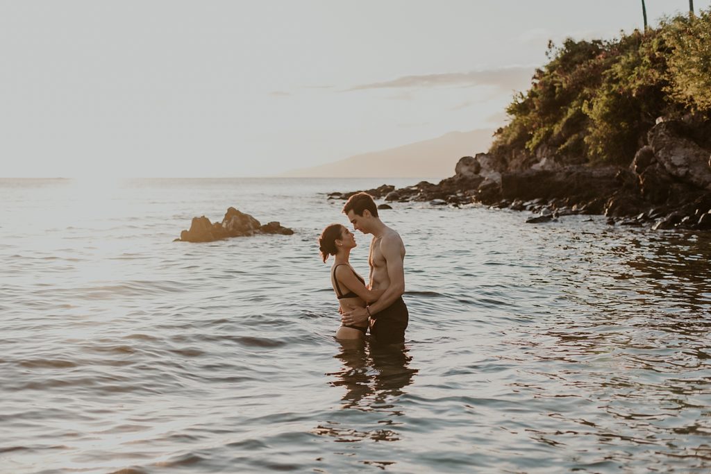 Couple looking at each other knee deep in the ocean