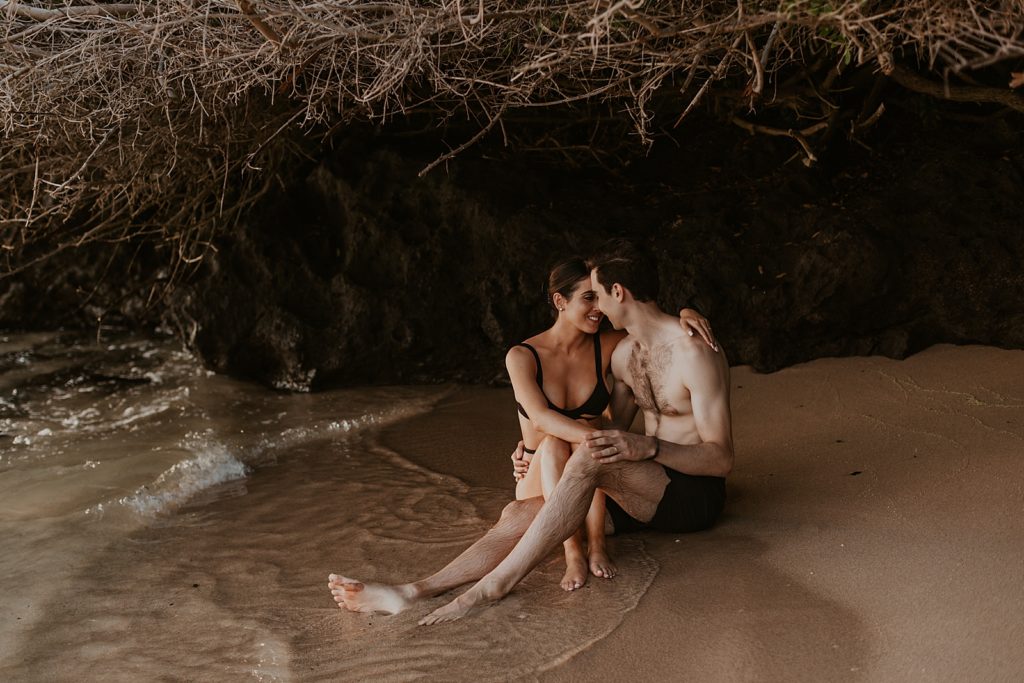 Couple sitting under dirt cove and nuzzling their noses