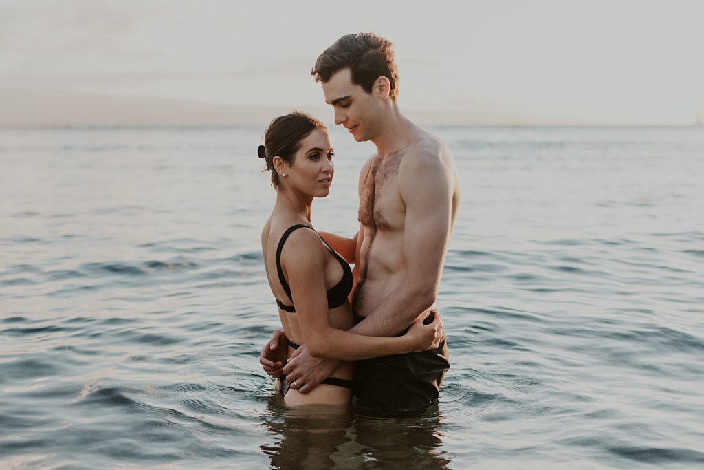 Couple holding each other waist deep in the ocean