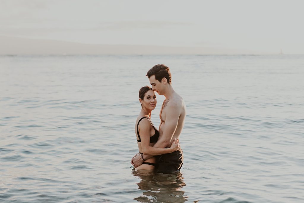 Couple holding each other while in the ocean water standing