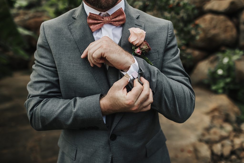 Closeup of Groom adjusting cuff with square cuff link
