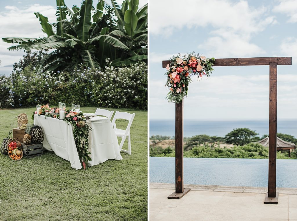 Detail shot of sweetheart table with tropical flowers with fruit and wooden arch with tropical flower