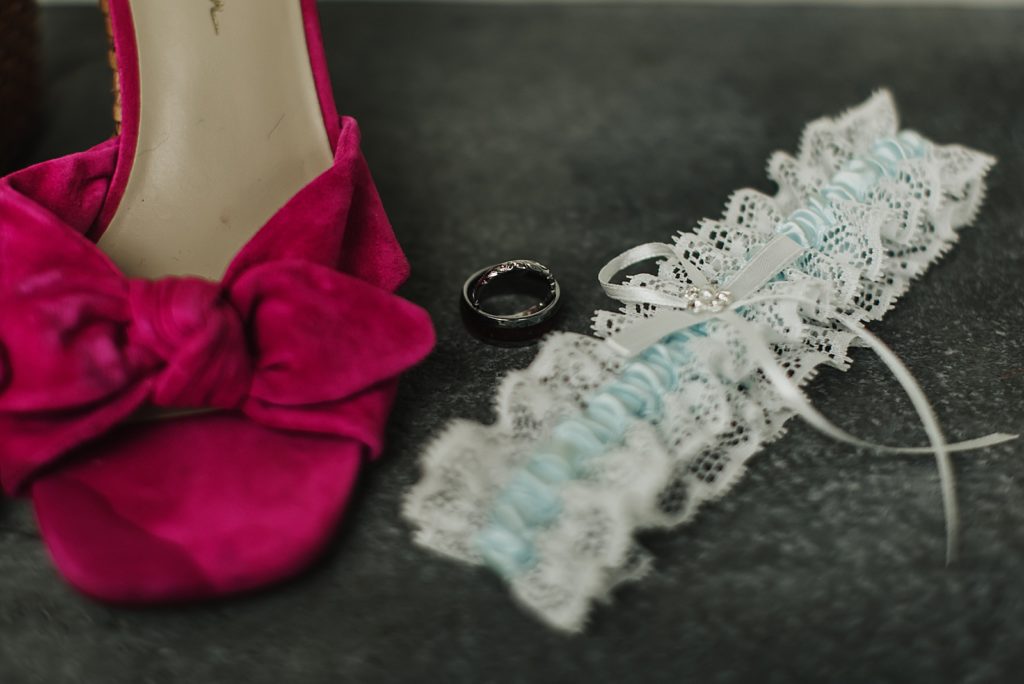 Detail shot of hot pink heel white garter and wedding band