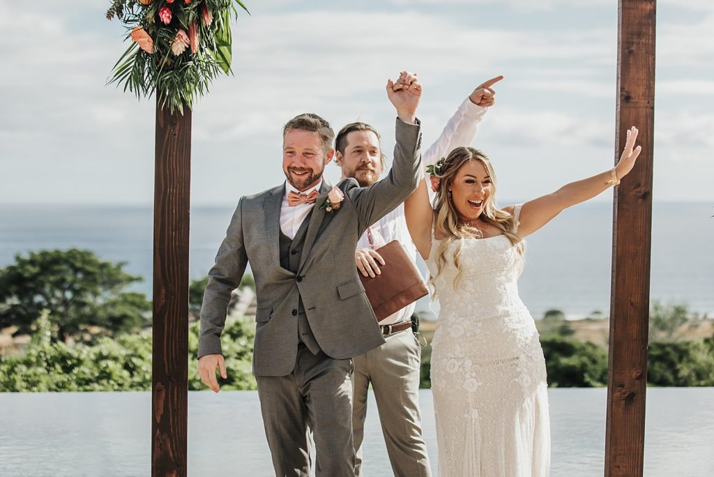 Bride and Groom raising hands in celebration after being pronounced husband and Wife
