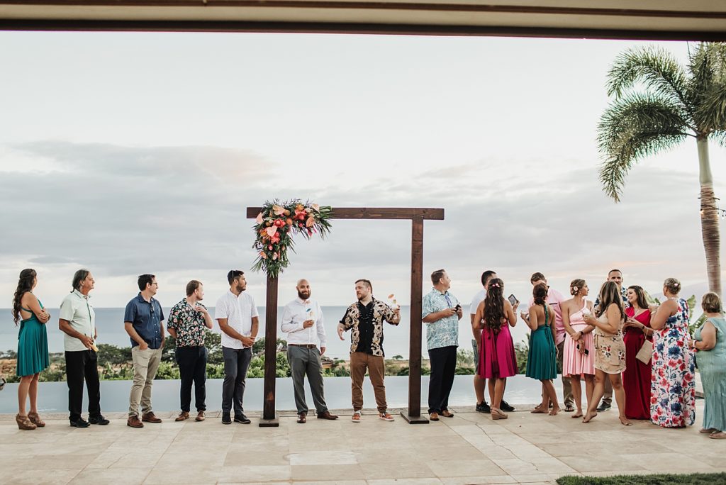 Guests gathered around wedding arch socializing