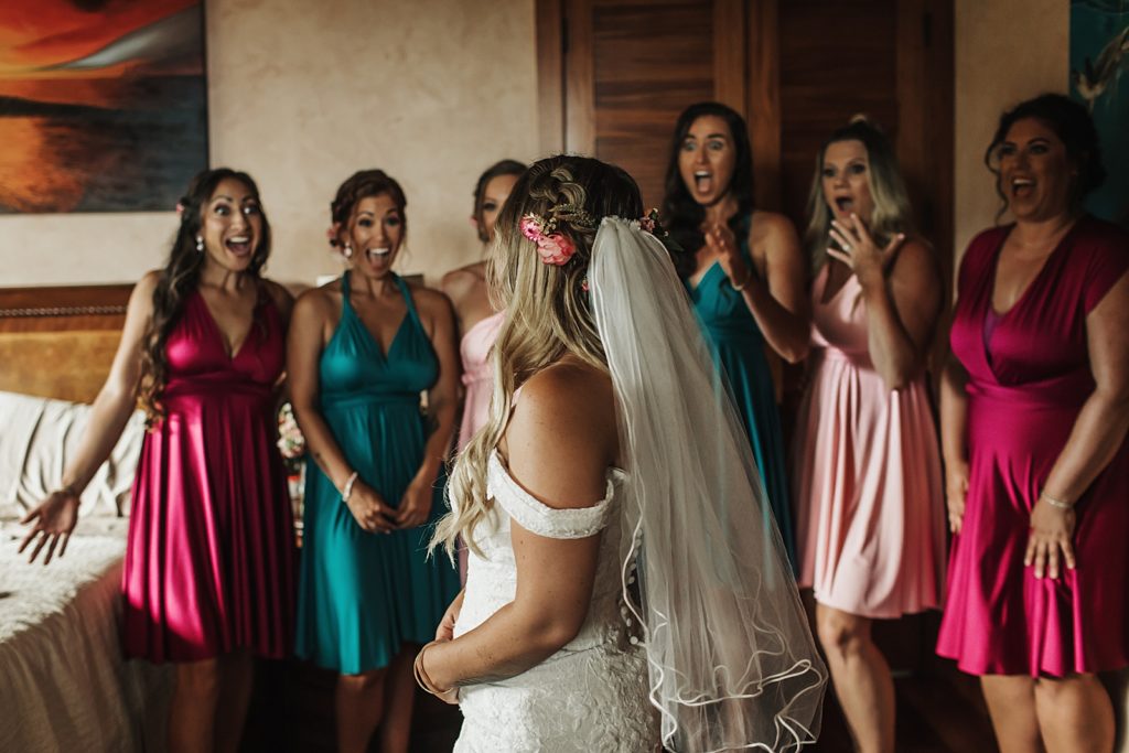 Bridesmaids reacting to Bride in wedding dress after getting ready