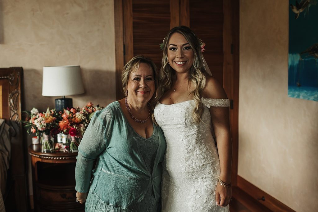 Bride with mother by side inside in getting ready room