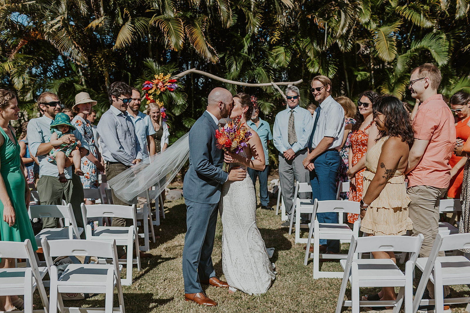Bride and Groom halfway through exit kissing with guests standing for outdoor Ceremony