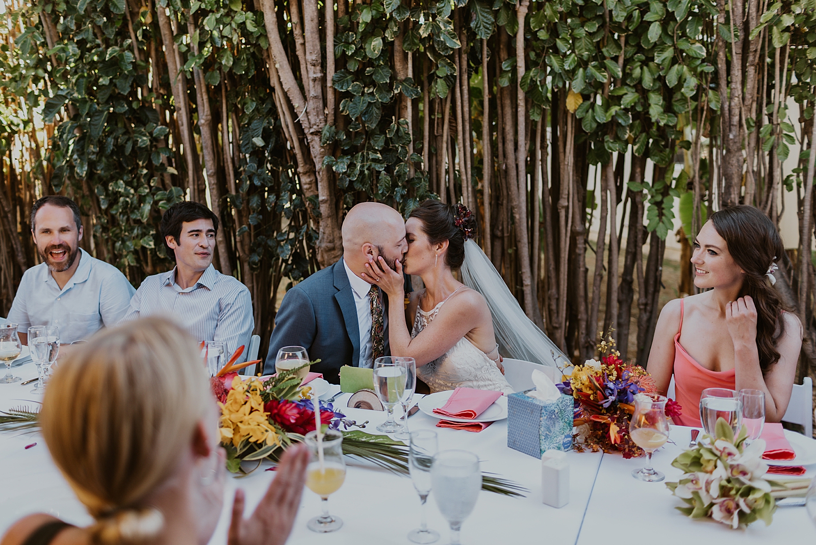Bride and Groom kissing at long reception table