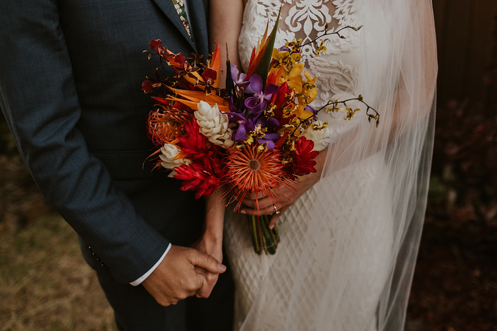 Bride and Groom holding hands and Bride holding colorful bouquet