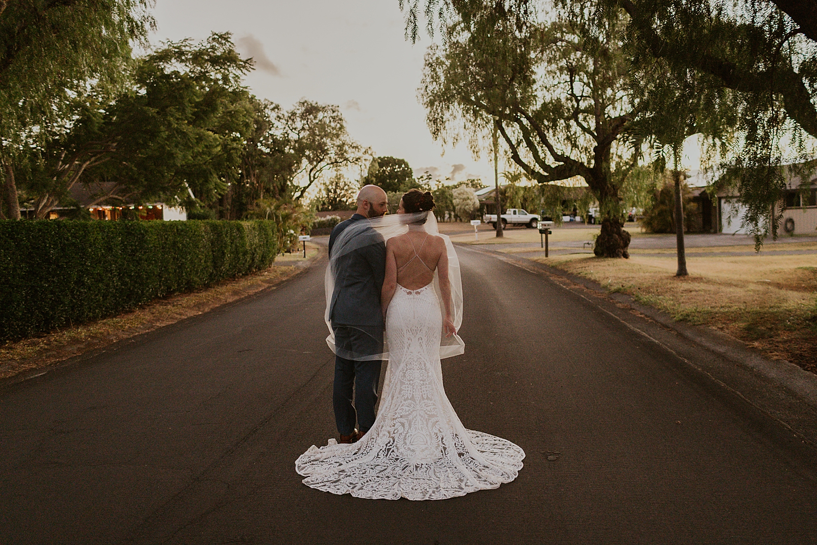 Bride and Groom side by side with veil covering both of them in the middle of the street