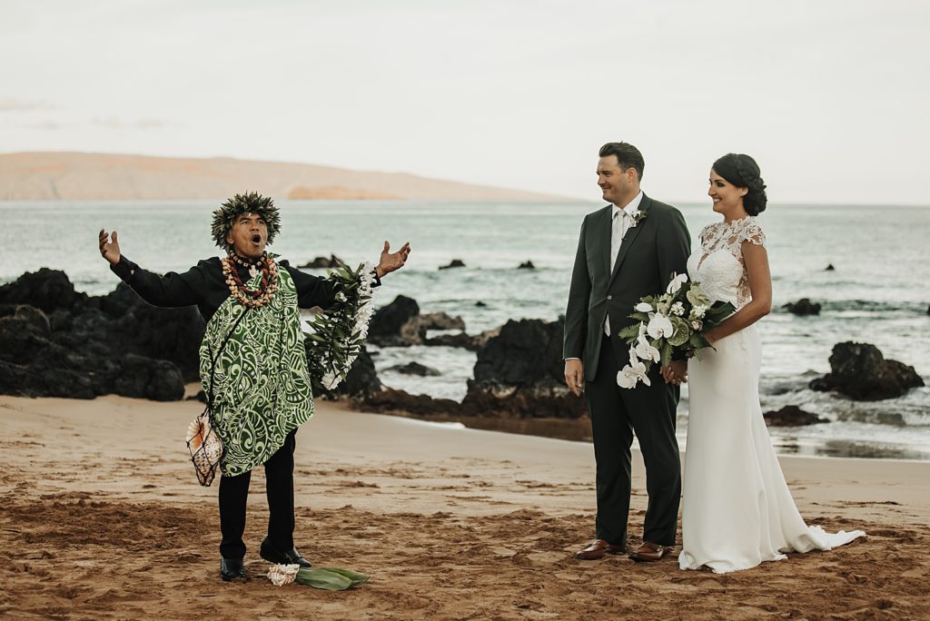 Officiant giving loud vocal intro to for Elopement on the beach with Bride and Groom