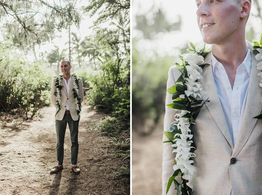 Groom with white flower vine around shoulders standing outside