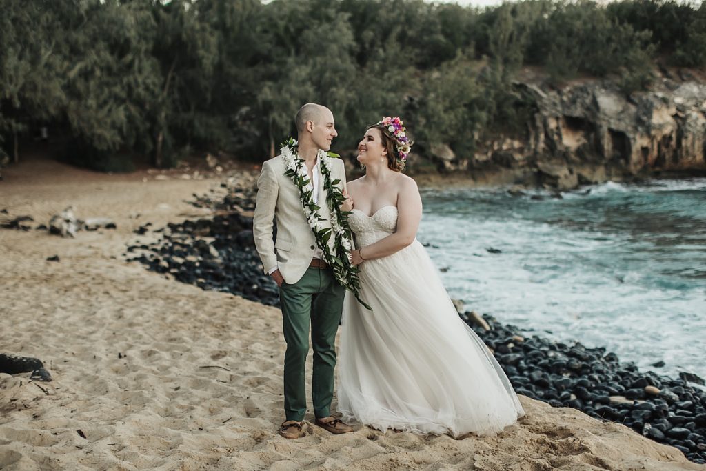 Bride holding Groom's arm by the ocean side