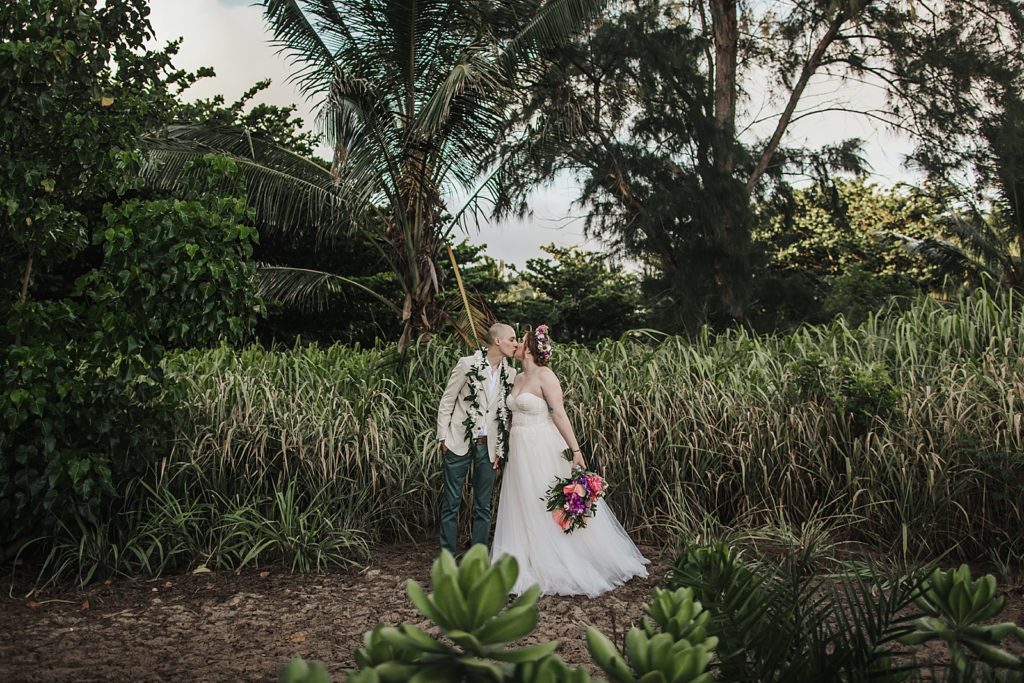 Bride and Groom kissing surrounded by greenery