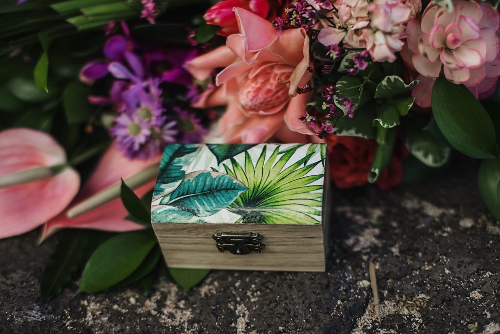 Detail shot of palm leaf box by colorful flowers