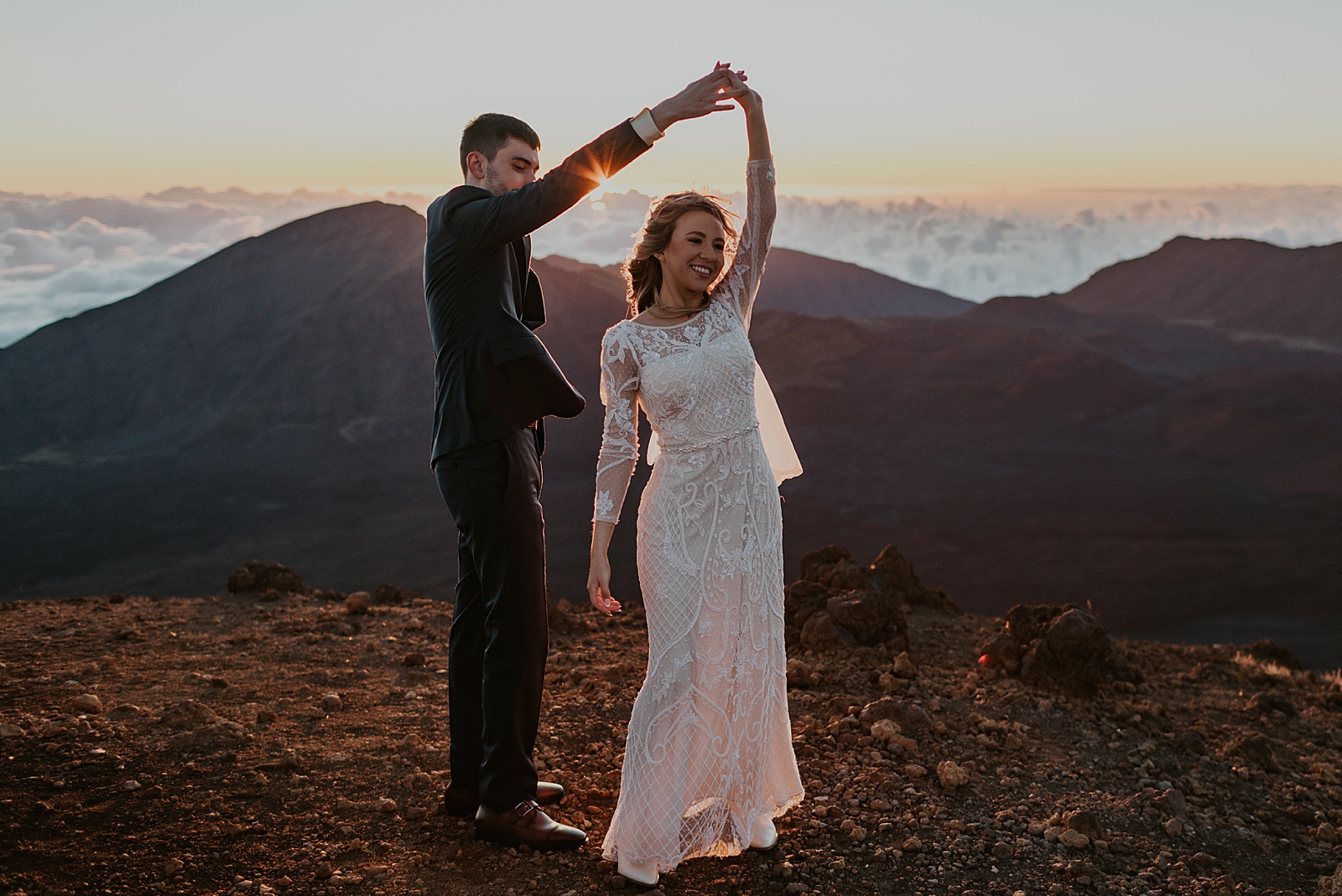 Bride twirling by Groom's hand on top of a mountain