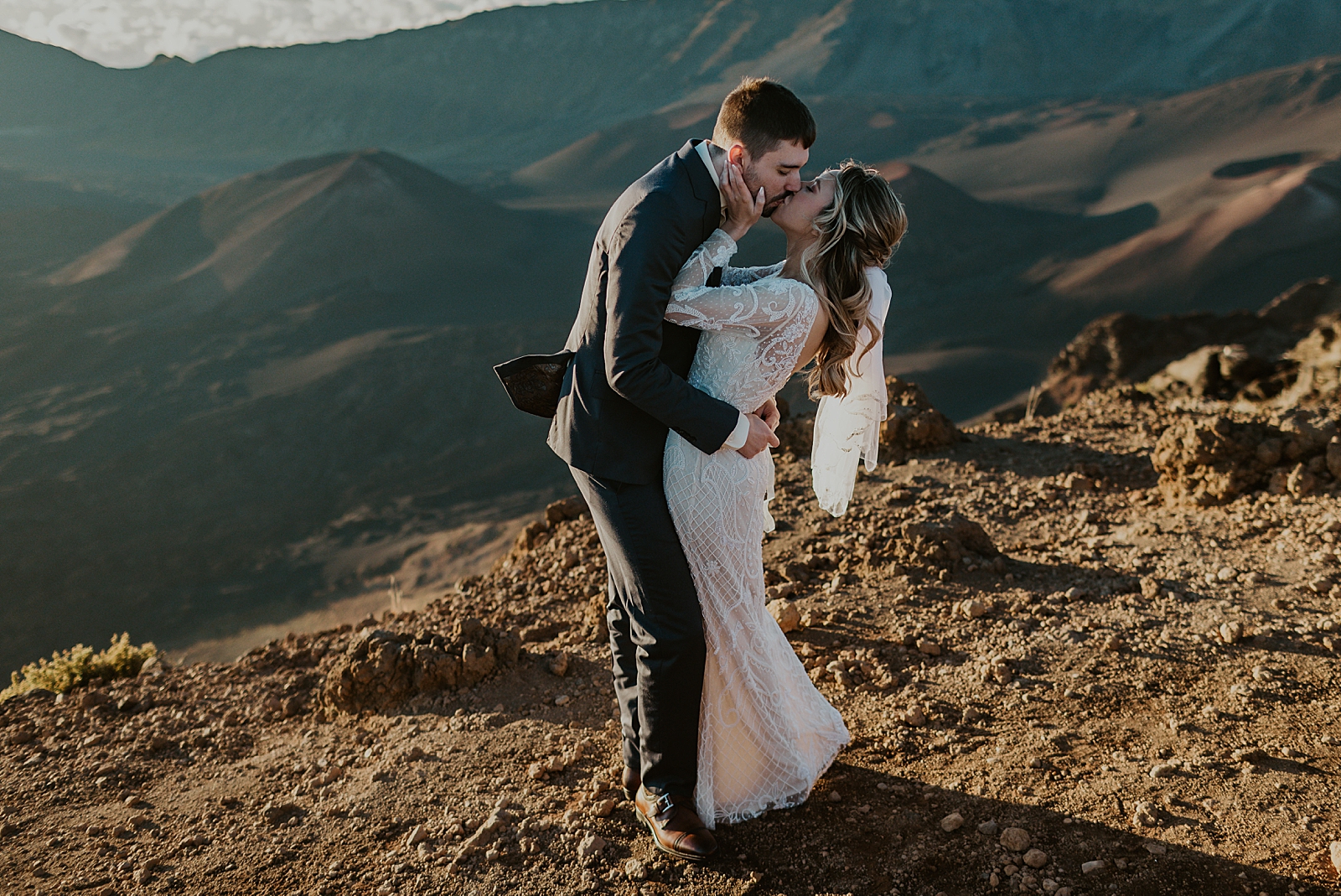 Bride and Groom kissing with dunes behind them