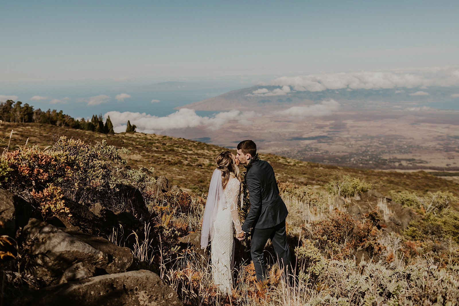 Bride and Groom kissing by green mountain side