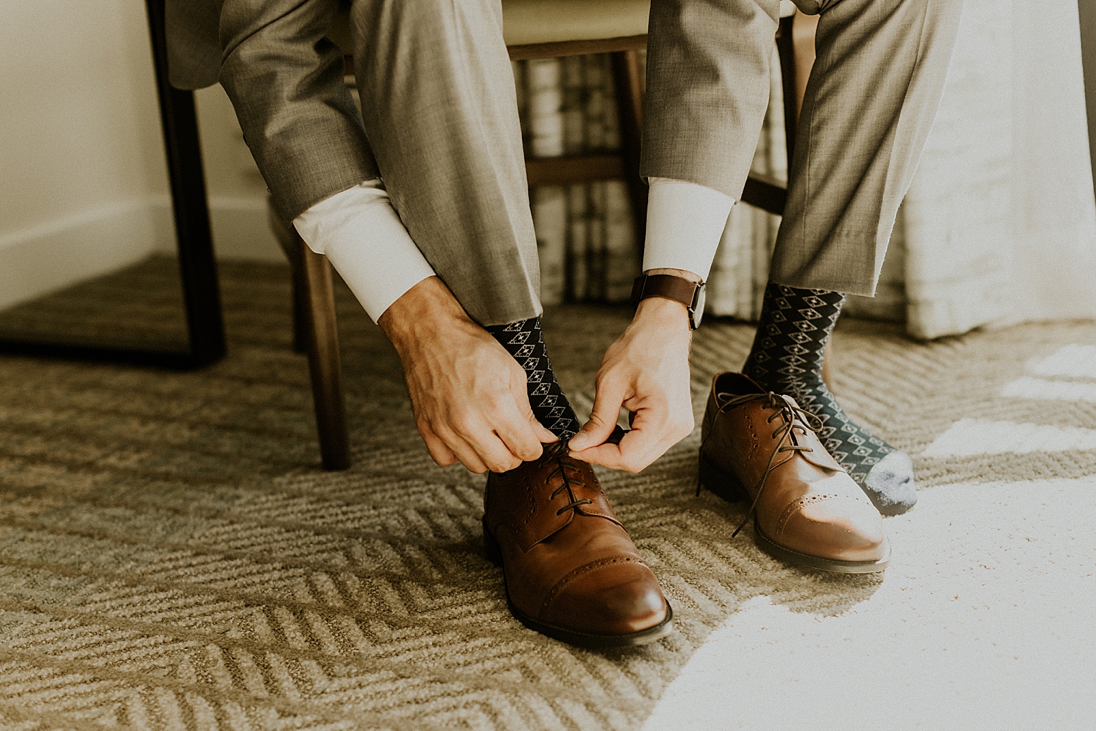 Closeup of Groom tying shoes inside Getting ready