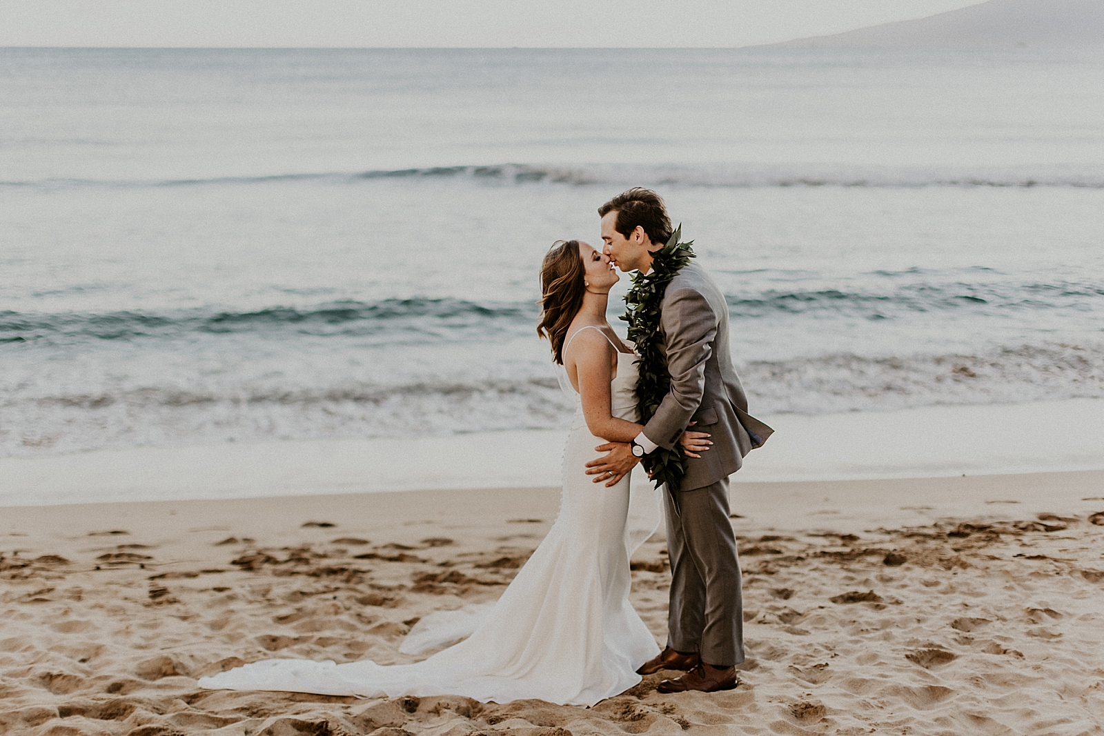Bride and Groom about to kiss and holding each other in front of the ocean