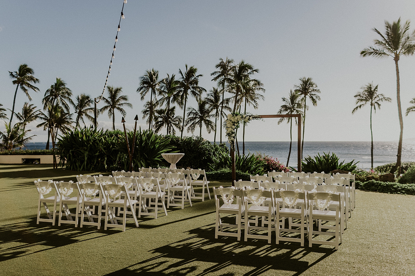 Detail shot of outdoor Ceremony area by the ocean with tall palm trees