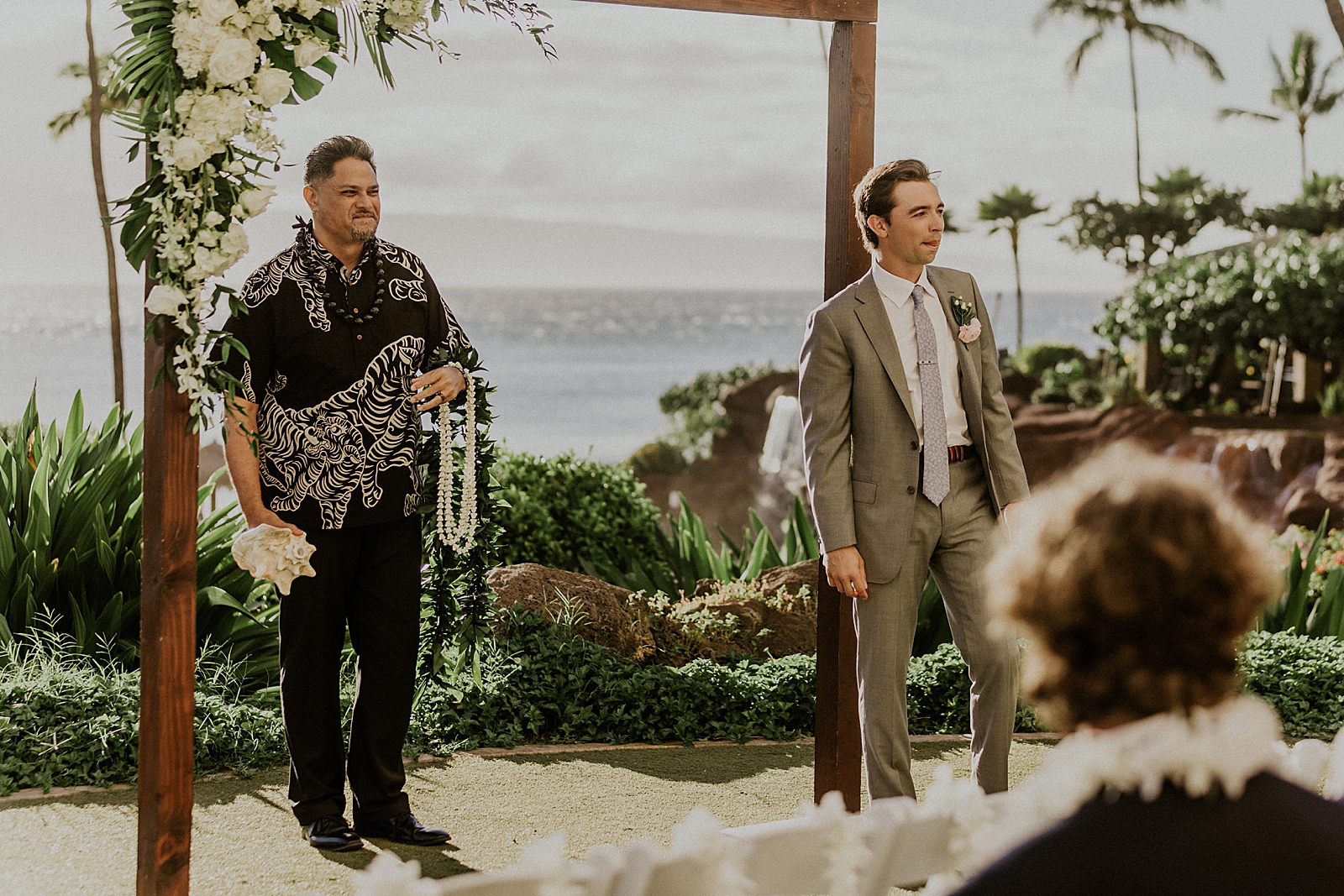 Groom waiting by the alter with officiant by the Oceanside 