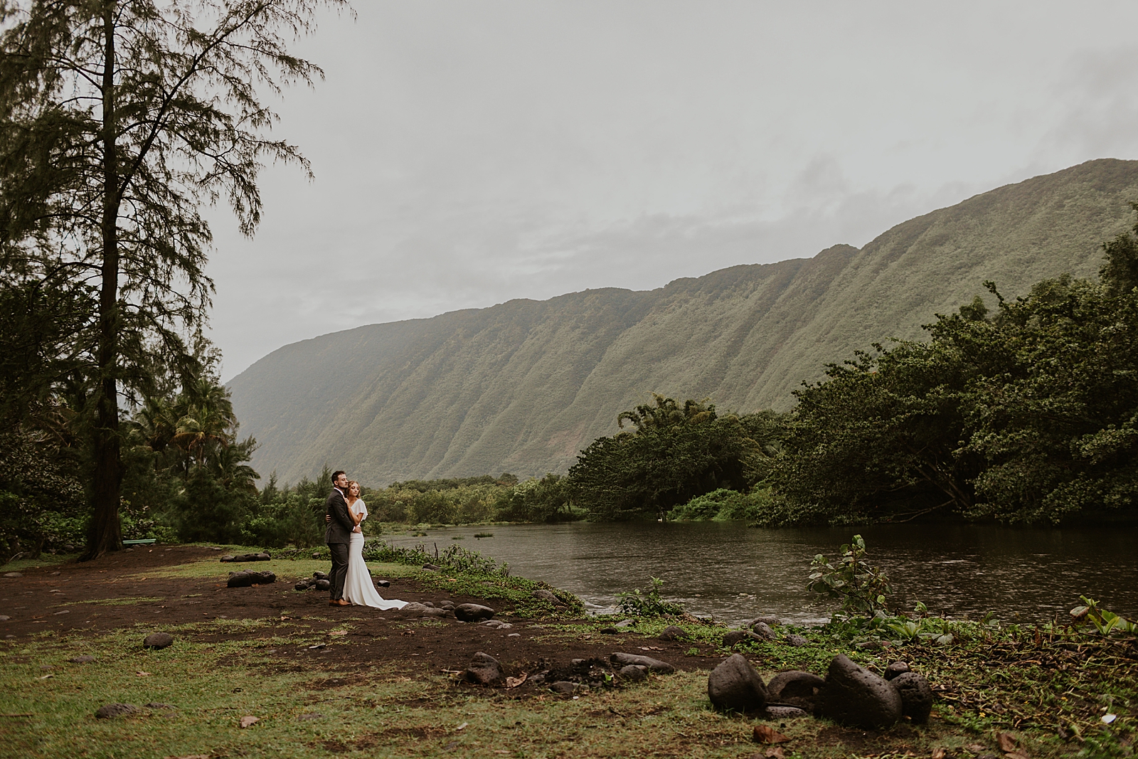 Wide shot of Bride and Groom holding each other by the mountain side