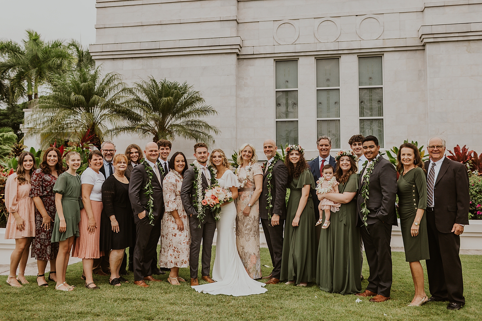 Bride and Groom with extended family portrait outside by palm trees