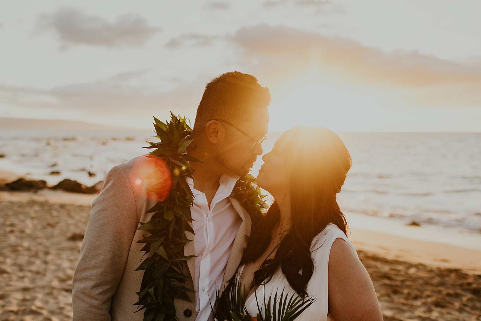 Bride and Groom staring at each other with sunset lens flare on the beach
