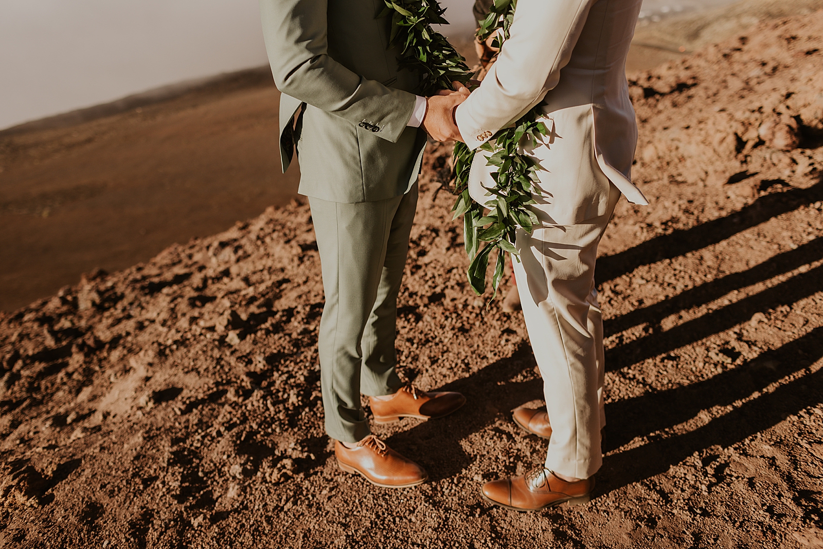 Lower angle of Grooms holding hands and standing on gravel during Elopement
