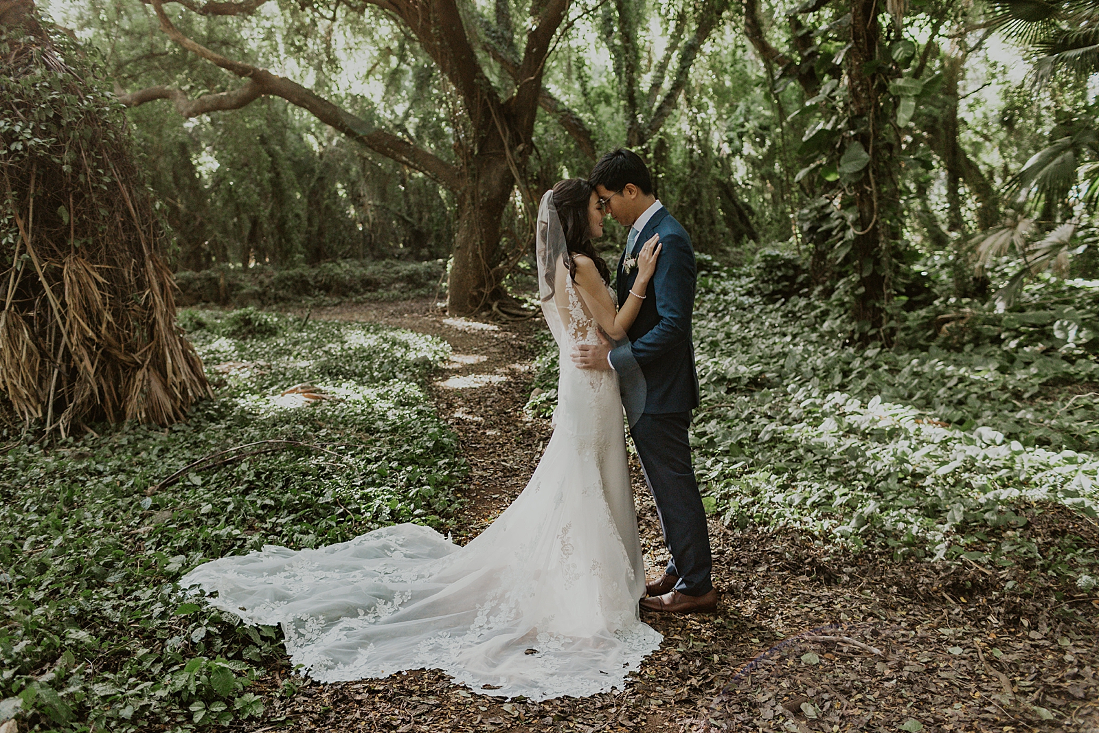 Bride and Groom resting their heads on each other out in the forest