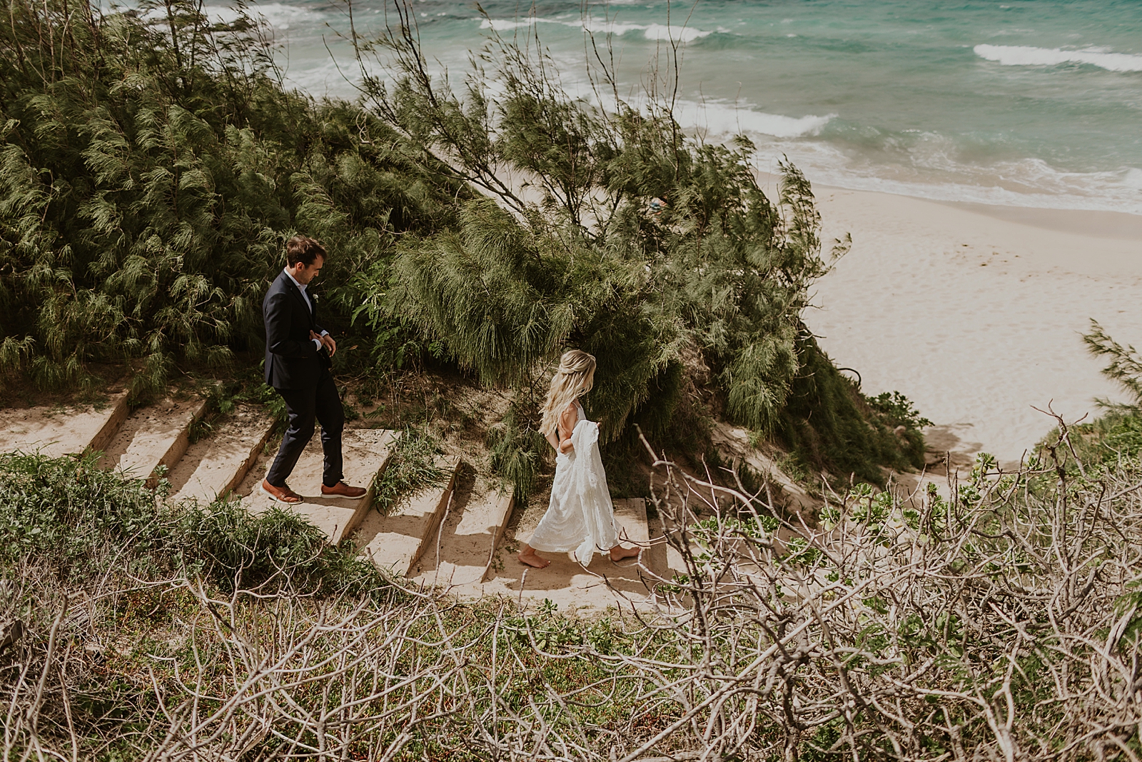Bride and Groom walking down beach staircase to the shoreline