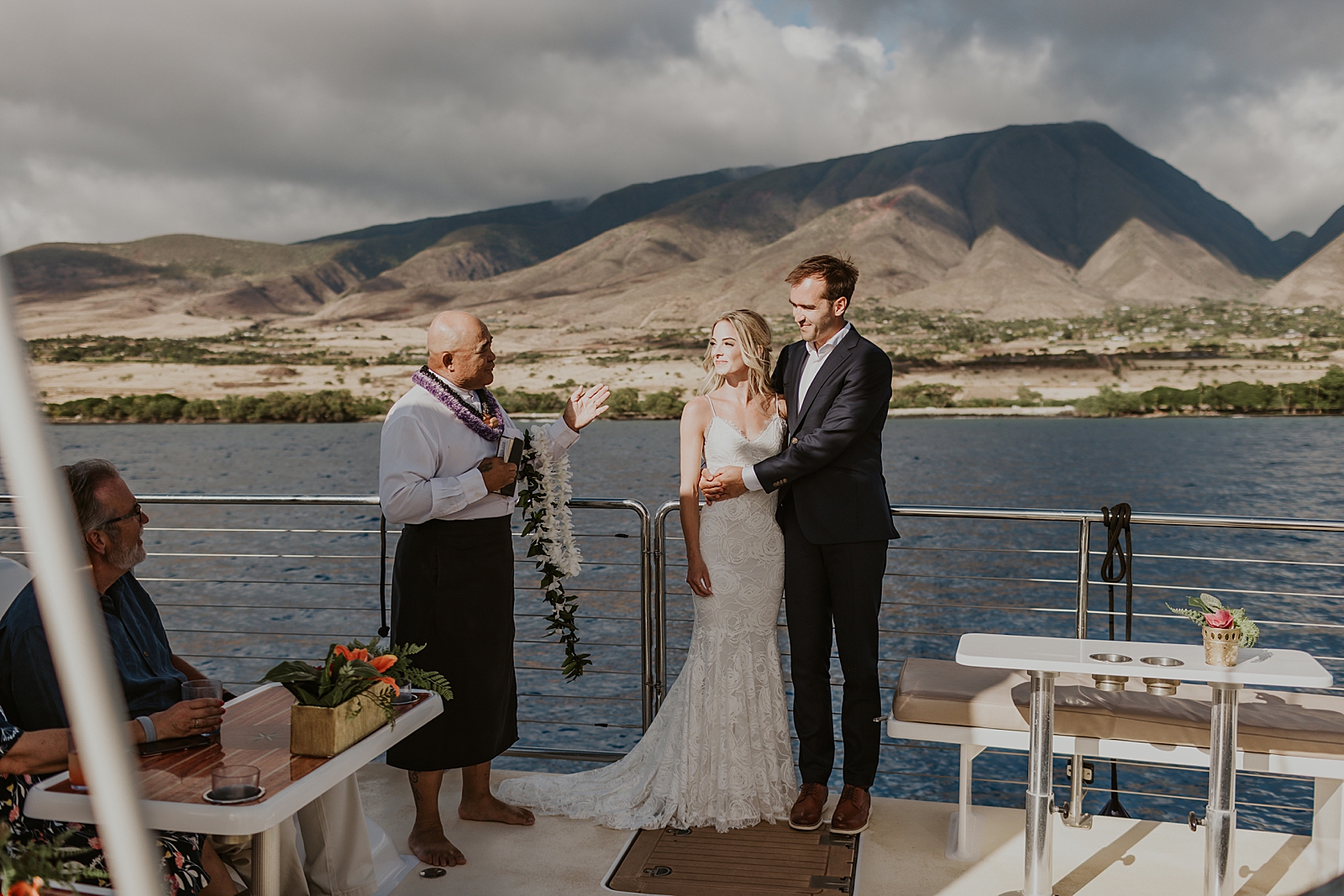 Bride and Groom holding each other and listening to officiant on the boat