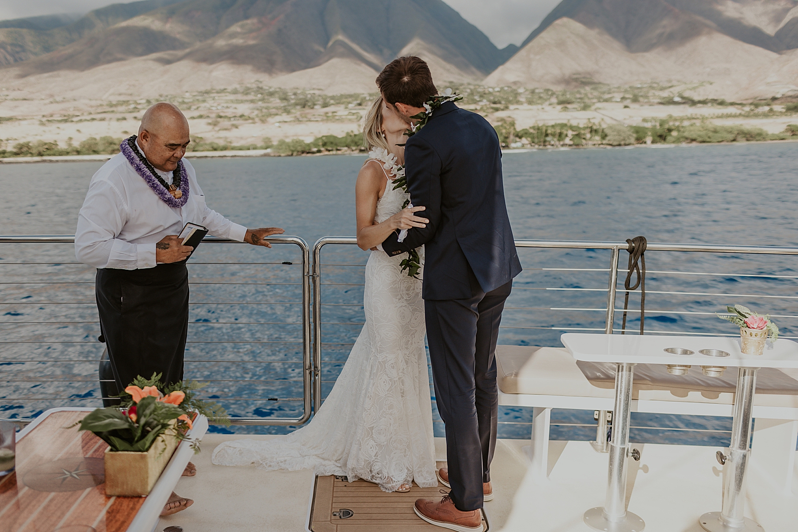 Bride and Groom kissing as just married Husband and wife on boat out on the ocean 